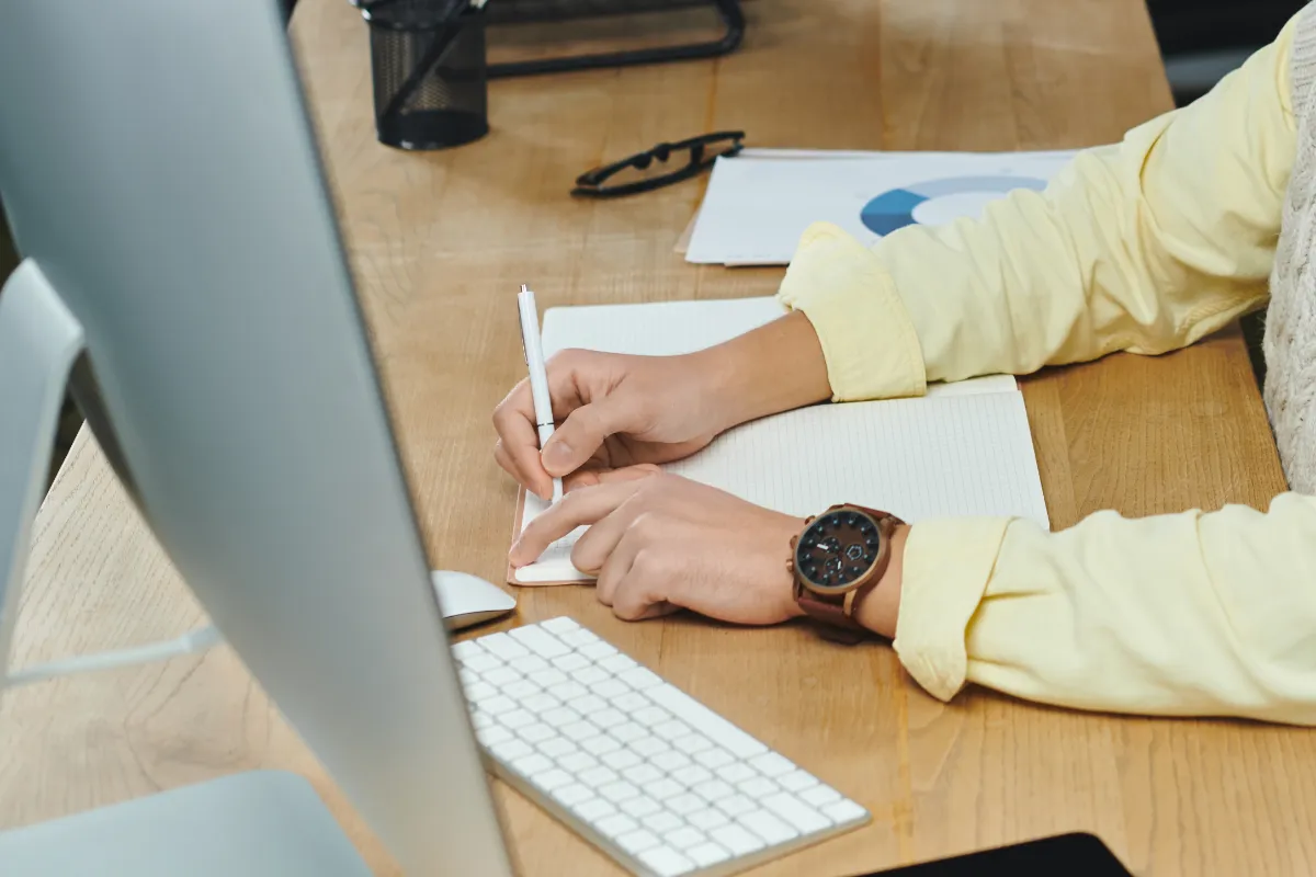 Young professional working at desk in office holding pencil to paper